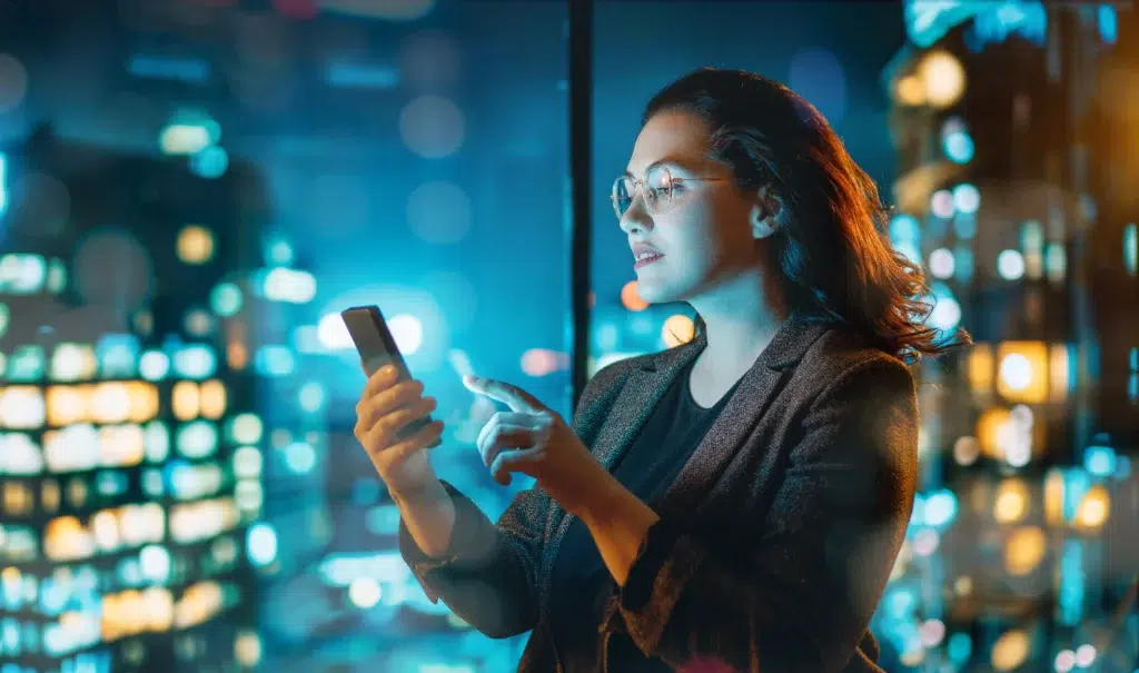 A businesswoman reviewing secure data on a smartphone, highlighting the need for data anonymization vs data masking in mobile enterprise workflows.